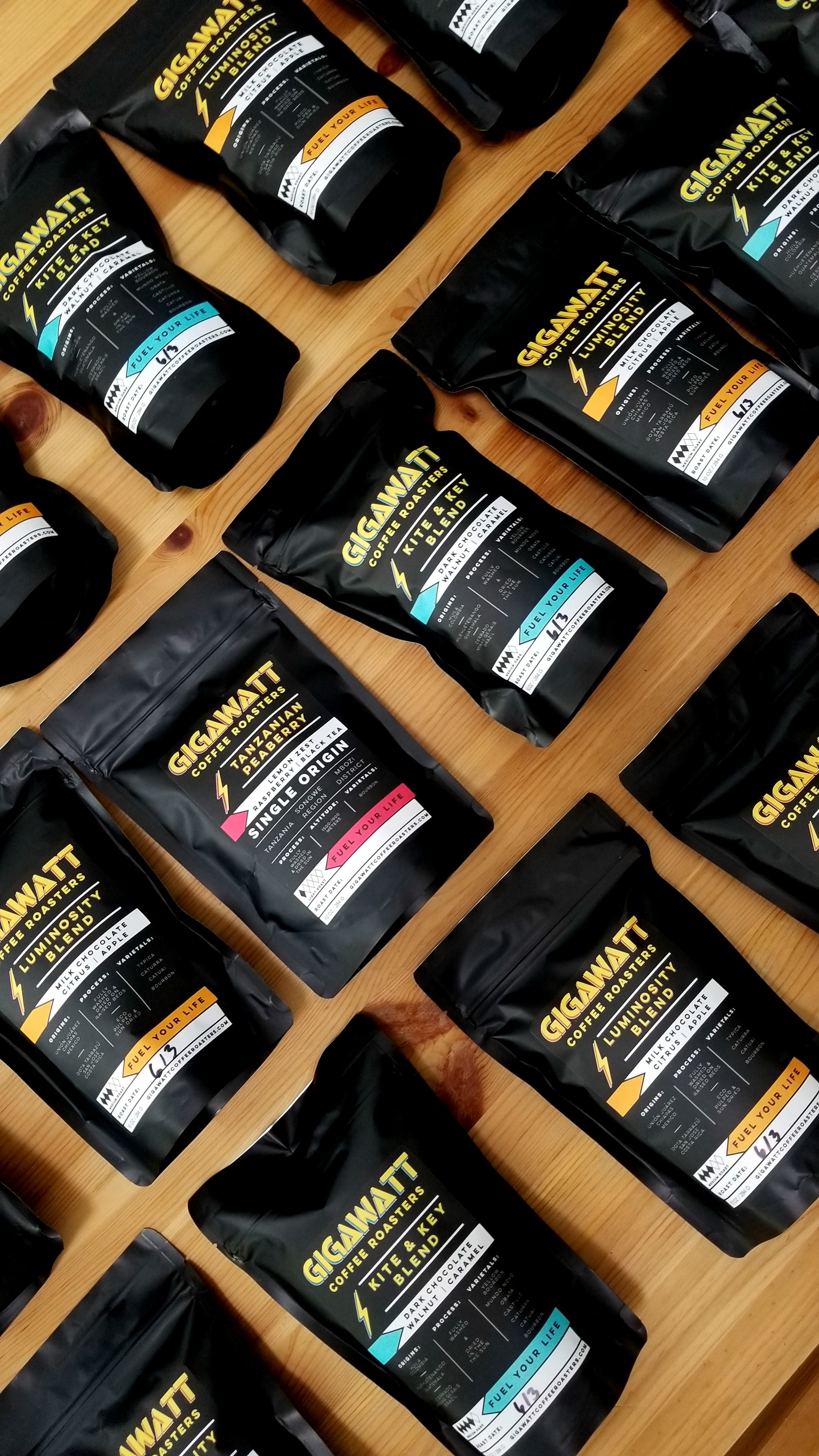 Chicago Web Co Shopify design for Gigawatt Coffee Roasters - specialty coffee bags with black and gold branding arranged on wooden display, premium coffee product showcase